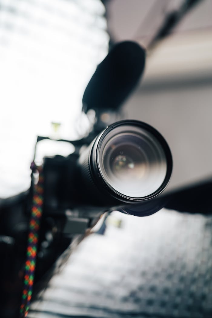 Close-up view of a professional camera lens with microphone, ideal for photography and videography enthusiasts.